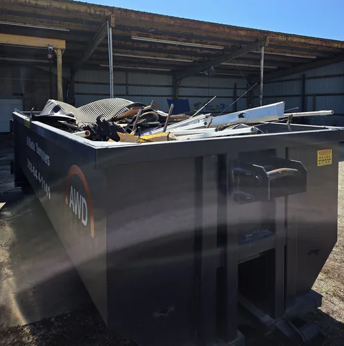 All Waste Dumpsters 25 yard container full of sheet metal, pipe and scrap under the steel overhang of a Belleview building