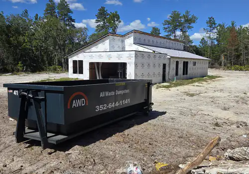 All Waste Dumpsters 20 yard container number 41 on bare sand in front of a wrapped new construction home in Ocala
